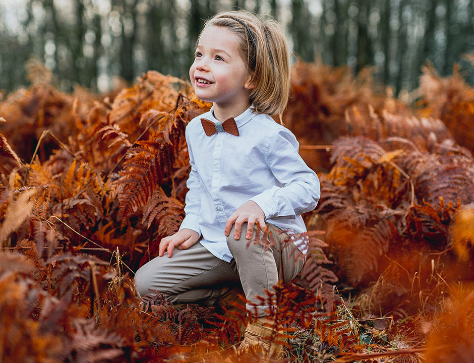 Enfant avec noeud papillon en bois